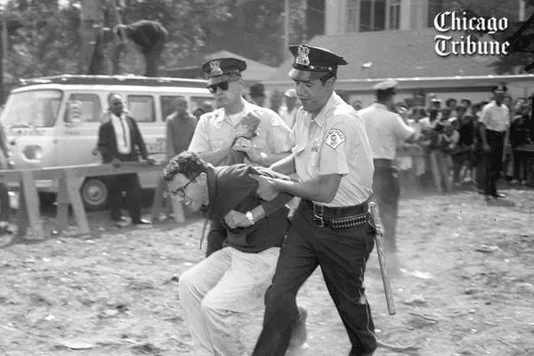 21-year-old Bernie Sanders grimaces while being dragged away by Chicago Police.