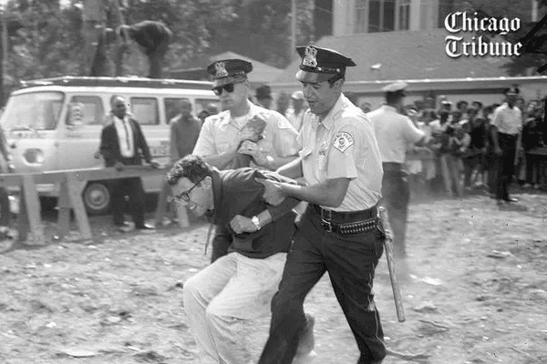 21-year-old Bernie Sanders grimaces while being dragged away by Chicago Police. 