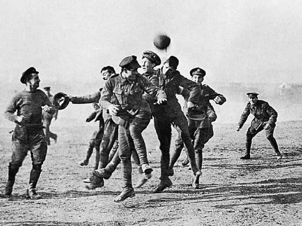 WWI soldiers during the Christmas Truce of 1914 playing an active game of soccer
